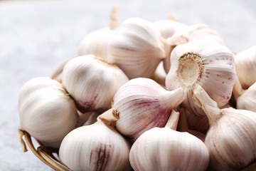Garlic in basket on grey wooden table