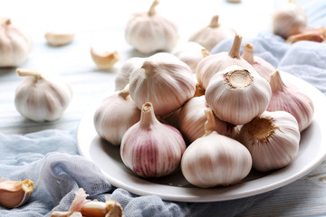 Garlic in plate on blue wooden table