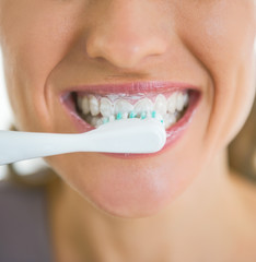 Closeup on happy woman brushing teeth