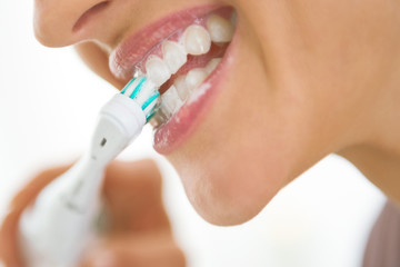 Obraz na płótnie Canvas Closeup on young woman brushing teeth