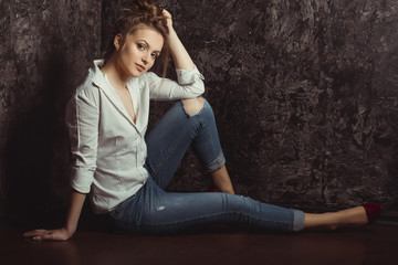 Fototapeta na wymiar Pretty brunette woman with natural makeup in shirt and torn jeans