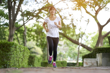 Women with headphones jogging and relaxing stroll in the park happy.