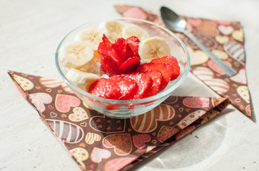 Two bowls of curd with strawberry and banana.