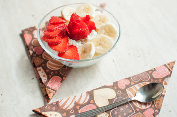 Two bowls of curd with strawberry and banana.