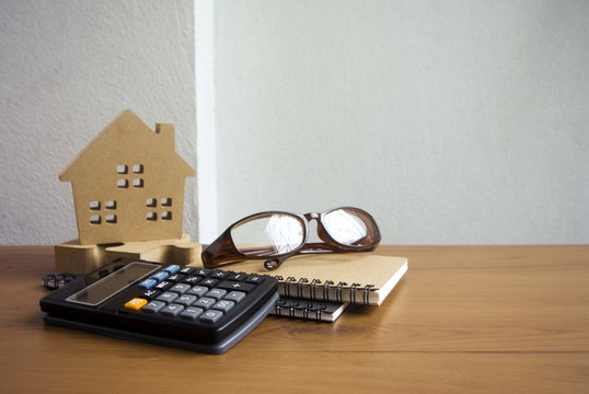 Wood Home And Book And Calculator With Eyeglasses In Finance Concept