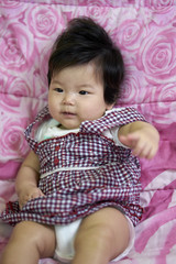 Fototapeta premium baby girl Asian, Cute kids in a good mood Lie down on the couch, They're so happy, They're so cute, They're so cute on the bed