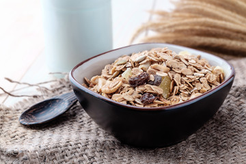 Breakfast cereals with dried fruits in a bowl on a wooden background.