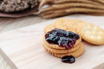 Cracker with jam on woodden background