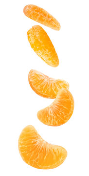 Isolated falling orange segments. Five peeled pieces of orange or tangerine fruit in the air isolated on white background with clipping path