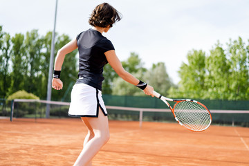Fototapeta na wymiar Beautiful young girl on the open tennis court