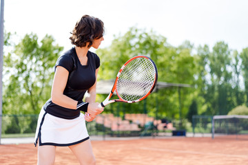 Beautiful young girl on the open tennis court