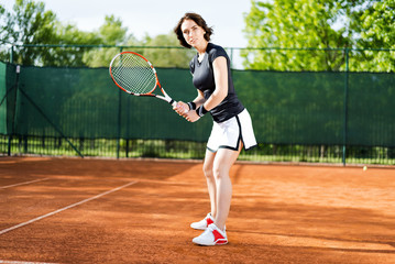 Fototapeta na wymiar Beautiful young girl on the open tennis court
