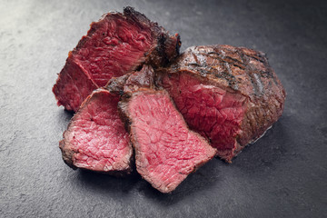 Barbecue Wagyu Point Steak bleu aufgeschnitten als close-up auf Schieferplatte