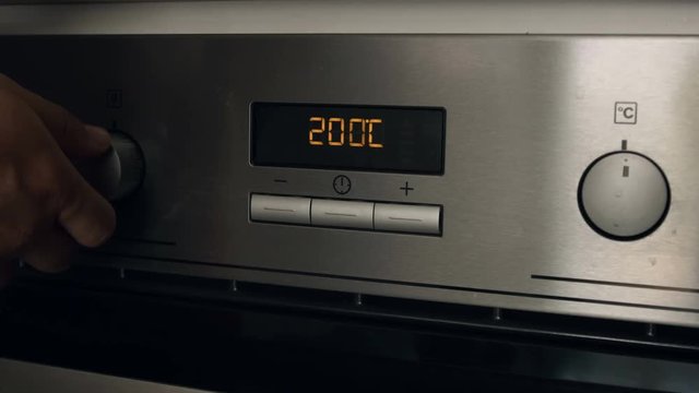Hand Adjusting Temperature On Electric Oven