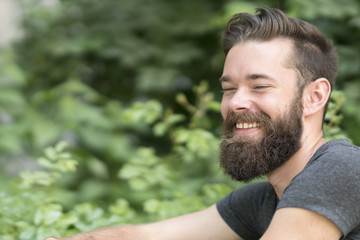 Close up portrait of an attractive smiling young guy in park