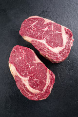 Zwei Stück rohe dry aged Kobe Entrecote Steaks als close-up auf Schieferplatte