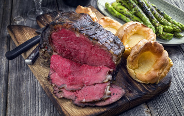 Barbecue dry aged Rib of Beef with green Asparagus and Yorkshire Pudding as close-up on an old...
