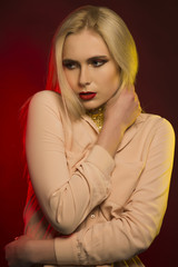 Seductive young model with bright makeup. Red and yellow studio light