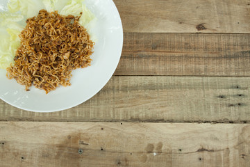 Thai food Noodle mix Canned fish and Vegetable in White plate on the wood.