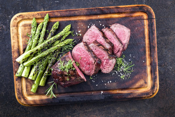 Barbecue Wagyu Hüftsteak mit grünen Spargel als close-up auf verbrannten Schneidebrett