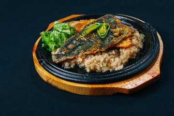 Fried rice with deep-fried spicy fish on a wooden board dumpling close up
