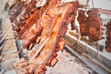 Roasted meat of beef cooking. Asado is traditional Argentine dish.