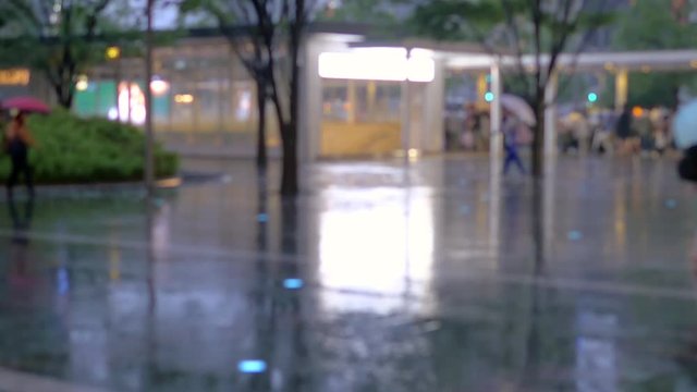 People walking in hard rain with umbrellas, defocused, blurred footage
