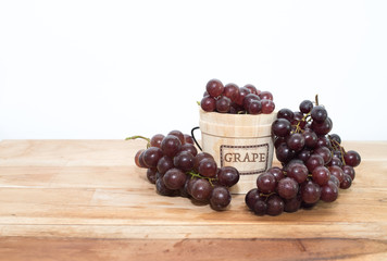 Small bucket full with grapes isolated on the wood background