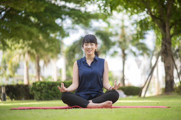 Beautiful yoga woman on green park