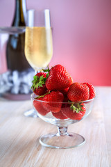 strawberries in a glass vase stands on the table