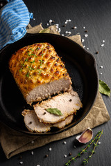 Roasted and sliced pork carbonade glazed with honey and mustard on iron pan