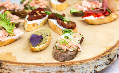 Different sandwiches with meat and fresh vegetables on wooden board