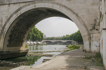 View on bridge of Umberto I and river Tiber from arc under Sant Angelo bridge in Rome, Italy.