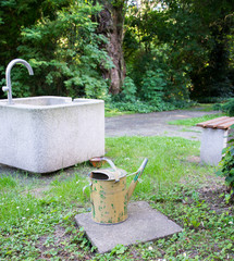 Alte Gießkanne und Wasserstelle