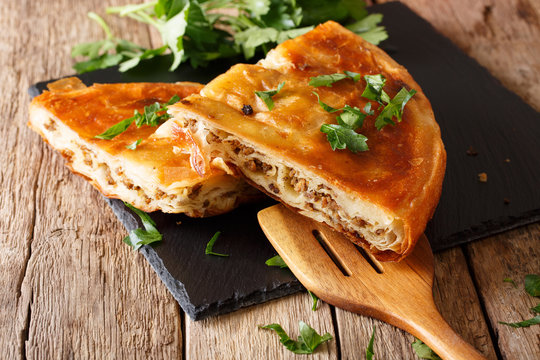 Fototapeta Delicious appetizer: Balkan burek with minced meat close-up. horizontal