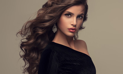 Brunette girl with long and shiny wavy hair . Beautiful model with curly hairstyle .
- 162164755