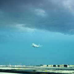 Fototapeta na wymiar commercial airplane taking off from commercial airport over cloudy sky