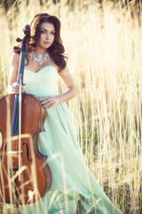 Girl with a cello in a tall grass © liyasov