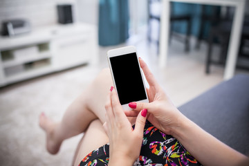 Young woman holding empty copy space white mobile phone in home.