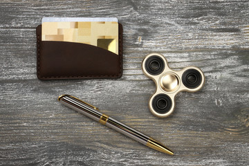 Gold fidget SPINNER stress relieving toy on wood background.