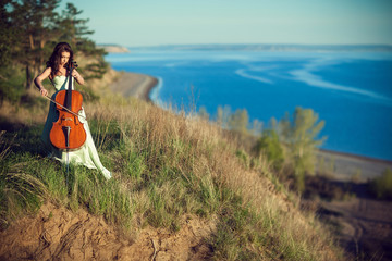 Woman with a cello in the woods © liyasov