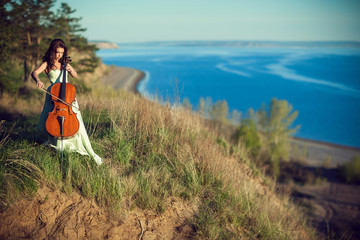 Woman with a cello in the woods
