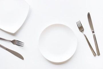 Two empty plates and cutlery on white background mockup