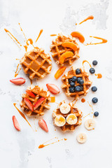 Traditional belgian waffles with fresh fruit and caramel. Flat lay, top view
