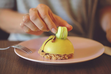 Woman eating dessert pistachio mousse cake close up