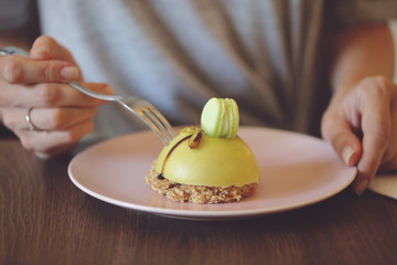 Woman eating dessert pistachio mousse cake close up