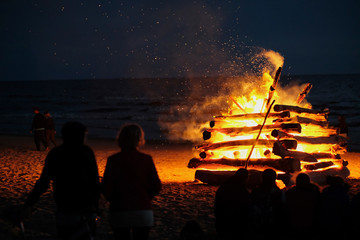 A large fire at the celebration of the summer solstice on the shore of the Gulf of Riga. Latvia. - obrazy, fototapety, plakaty