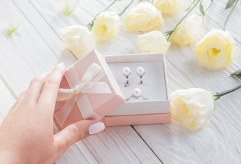 Woman opens a gift box with jewellery