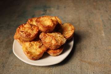 White dish with muffins on a wooden background.