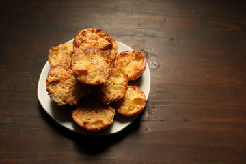 White dish with muffins on a wooden background.